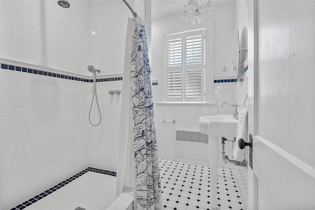 310 Columbia Ave, West View, PA 15229 - bathroom with a tile shower, tile walls, a chandelier, tile patterned floors, and wainscoting