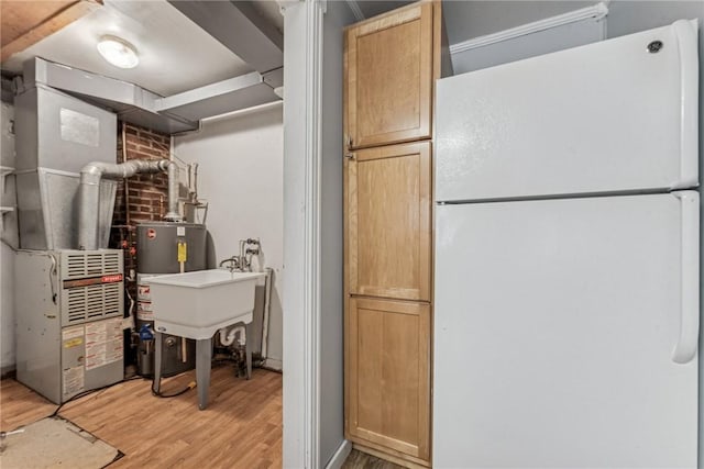 339 Foster Rd N, Versailles, PA 15137 - kitchen with freestanding refrigerator, light wood-style flooring, and gas water heater