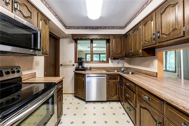 483 Twin Lakes Rd, Unity Twp, PA 15650 - kitchen with stainless steel appliances, light countertops, dark brown cabinetry, and light flooring