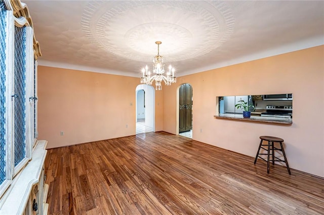 483 Twin Lakes Rd, Unity Twp, PA 15650 - unfurnished room featuring arched walkways, wood finished floors, and a chandelier