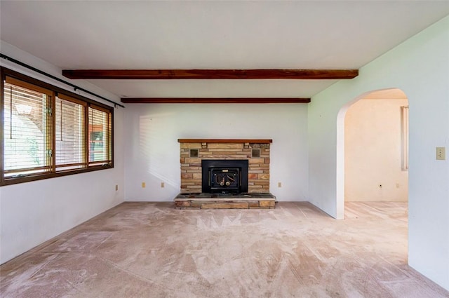 483 Twin Lakes Rd, Unity Twp, PA 15650 - unfurnished living room featuring arched walkways, beam ceiling, carpet, and a stone fireplace