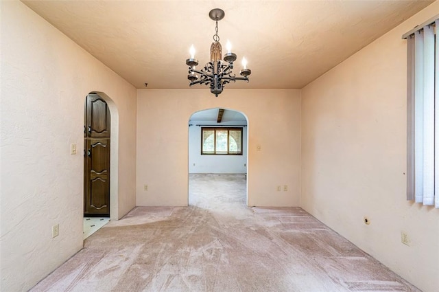 483 Twin Lakes Rd, Unity Twp, PA 15650 - unfurnished room featuring arched walkways, light colored carpet, and a chandelier