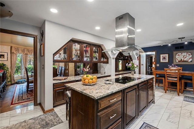 633 Westminster Rd, Hermitage, PA 16148 - kitchen with black electric stovetop, light marble finish floors, island exhaust hood, glass insert cabinets, and dark brown cabinets