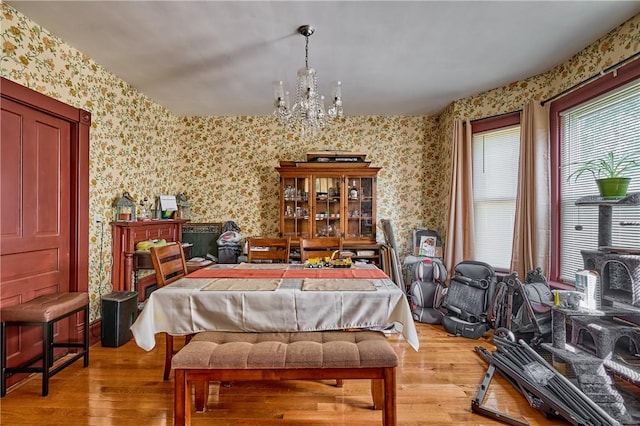110 Pattison St, Evans City Boro, PA 16033 - bedroom with wallpapered walls, a chandelier, light wood-style floors, and a wood stove