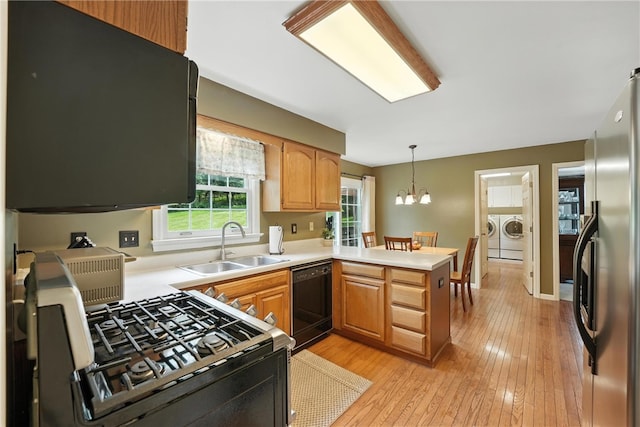 708 Reiser Ct, Cranberry Twp, PA 16066 - kitchen featuring black dishwasher, independent washer and dryer, range with gas stovetop, freestanding refrigerator, and a peninsula