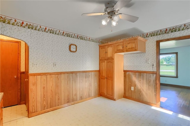 5684 Sandy Lake Polk, Sandy Lake Twp, PA 16145 - spare room featuring wainscoting, light floors, wood walls, wallpapered walls, and a ceiling fan
