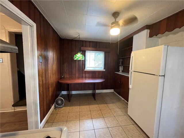 2220 Cronemeyer St, Mckeesport, PA 15132 - kitchen with freestanding refrigerator, wooden walls, ceiling fan, and light tile patterned flooring