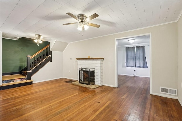 130 Pershing Blvd, Nemacolin, PA 15351 - unfurnished living room with ceiling fan, a brick fireplace, stairs, ornamental molding, and hardwood / wood-style flooring