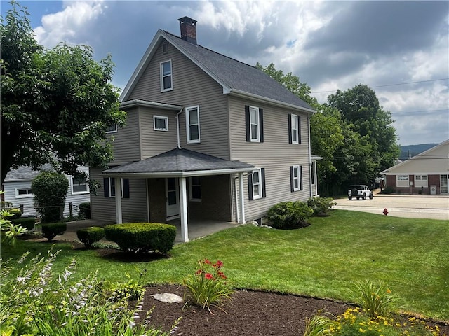 15 S 7th St, Youngwood, PA 15697 - back of house featuring a chimney, a yard, and roof with shingles