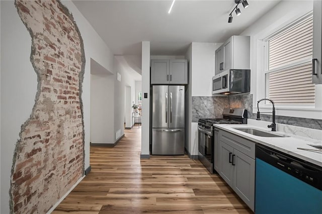323 N Balph Ave, Ross Twp, PA 15202 - kitchen featuring appliances with stainless steel finishes, gray cabinets, light wood finished floors, decorative backsplash, and light countertops