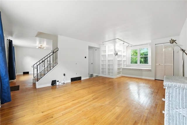445 Pacific Ave, Forest Hills Boro, PA 15221 - unfurnished living room with light wood-style flooring, stairs, and a chandelier