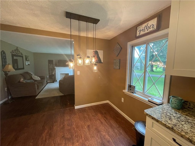 17 Evergreen, Hempfield Twp, PA 16125 - dining room featuring dark wood finished floors, a textured ceiling, and a fireplace