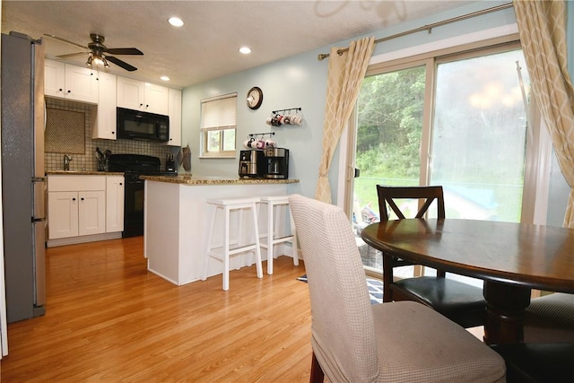 4095 Overlook St, South Park, PA 15129 - kitchen featuring black appliances, white cabinetry, decorative backsplash, light wood-style floors, and ceiling fan