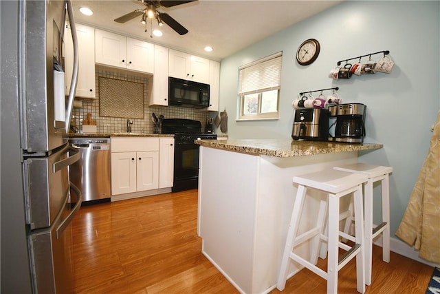 4095 Overlook St, South Park, PA 15129 - kitchen with black appliances, a peninsula, white cabinetry, a ceiling fan, and recessed lighting