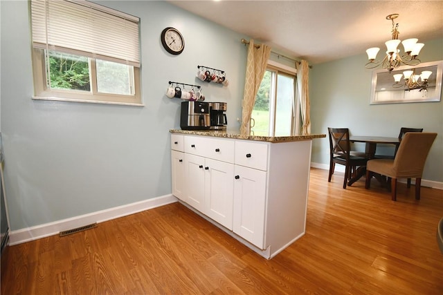 4095 Overlook St, South Park, PA 15129 - kitchen with a peninsula, light wood-style floors, white cabinetry, a chandelier, and stone counters