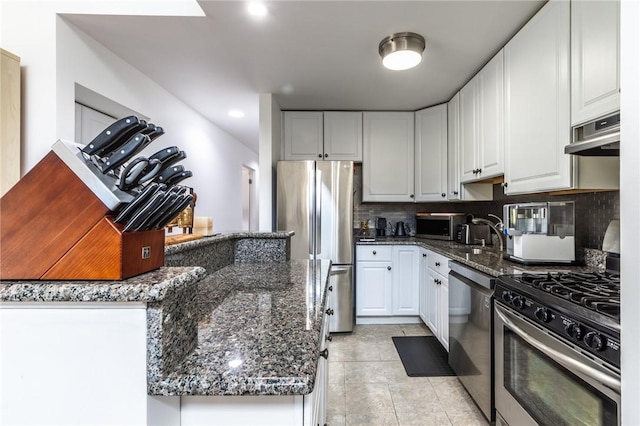 2207 Kenzie Dr, Robinson Twp, PA 15205 - kitchen featuring appliances with stainless steel finishes, decorative backsplash, exhaust hood, dark stone counters, and white cabinets