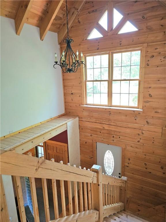 459 Big Knob Rd, New Sewickley Twp, PA 15074 - stairs with high vaulted ceiling, wood walls, a chandelier, and a wooden ceiling with exposed beams