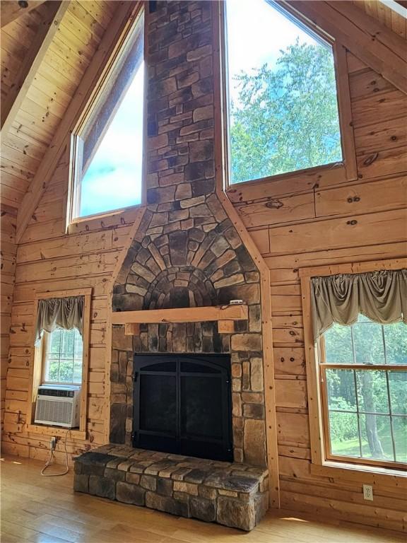 459 Big Knob Rd, New Sewickley Twp, PA 15074 - unfurnished living room featuring wood-type flooring, plenty of natural light, wooden ceiling, wood walls, and a fireplace