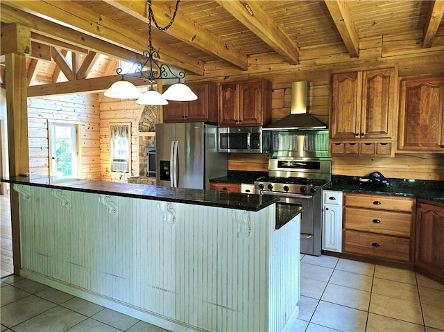 459 Big Knob Rd, New Sewickley Twp, PA 15074 - kitchen featuring appliances with stainless steel finishes, wall chimney exhaust hood, dark countertops, wood walls, and light tile patterned floors