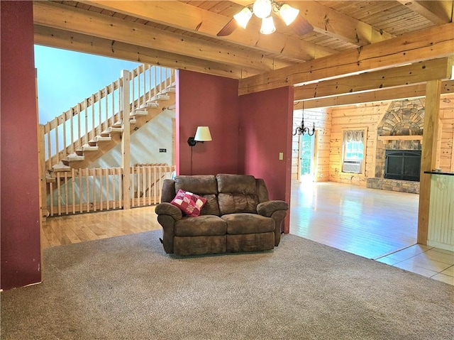 459 Big Knob Rd, New Sewickley Twp, PA 15074 - carpeted living room with a wooden ceiling with exposed beams, ceiling fan, wood walls, a fireplace, and plenty of natural light