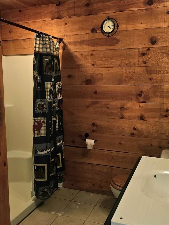 459 Big Knob Rd, New Sewickley Twp, PA 15074 - bathroom featuring wooden walls, tile patterned floors, and a stall shower