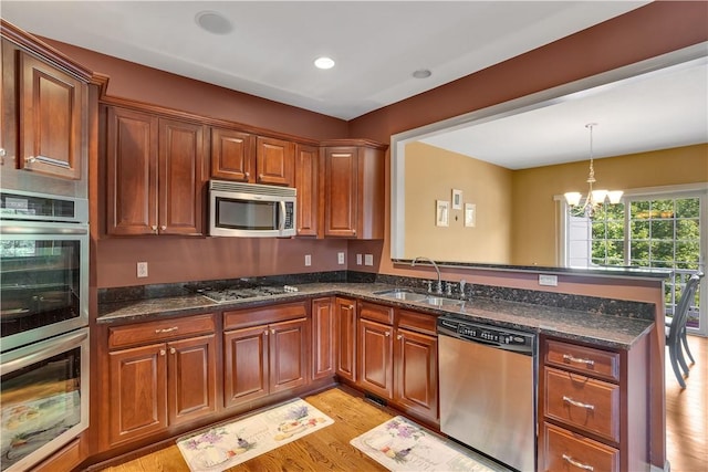 371 Marshall Heights Dr, Marshall, PA 15090 - kitchen with appliances with stainless steel finishes, a peninsula, light wood finished floors, a chandelier, and pendant lighting