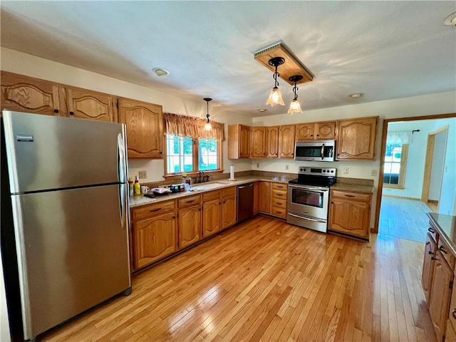 245 Chippewa Dr, Neshannock Twp, PA 16105 - kitchen featuring appliances with stainless steel finishes, brown cabinets, light wood-style floors, and decorative light fixtures