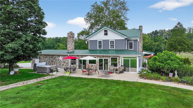 160 Railroad St, Hempfield Twp, PA 15665 - back of property with a chimney, stone siding, a patio, a lawn, and a metal roof