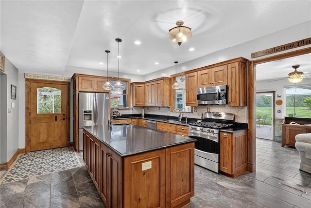 160 Railroad St, Hempfield Twp, PA 15665 - kitchen featuring appliances with stainless steel finishes, dark countertops, backsplash, brown cabinets, and recessed lighting