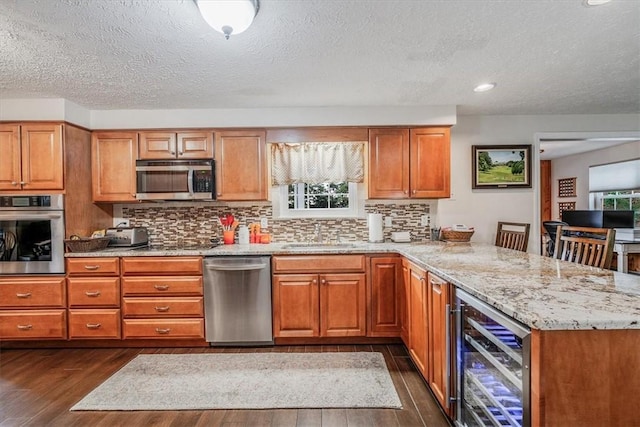 27 Watson St, Leet Twp, PA 15143 - kitchen with beverage cooler, stainless steel appliances, dark wood-style floors, a peninsula, and brown cabinetry