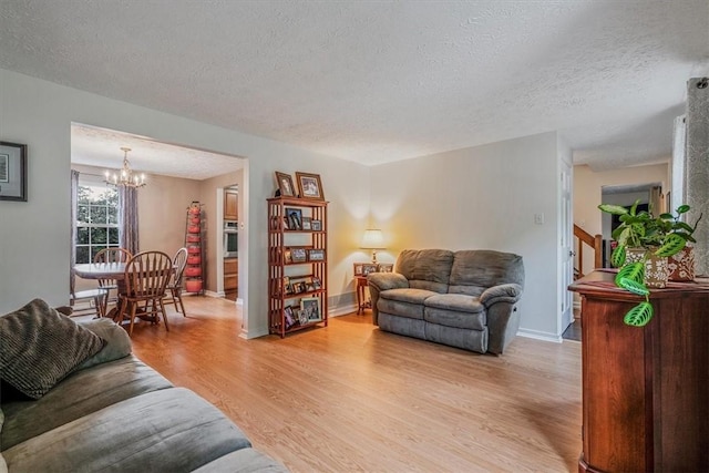 27 Watson St, Leet Twp, PA 15143 - living area with a chandelier, light wood-style floors, and a textured ceiling