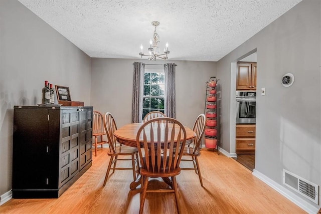 27 Watson St, Leet Twp, PA 15143 - dining room featuring light wood finished floors, a chandelier, and a textured ceiling