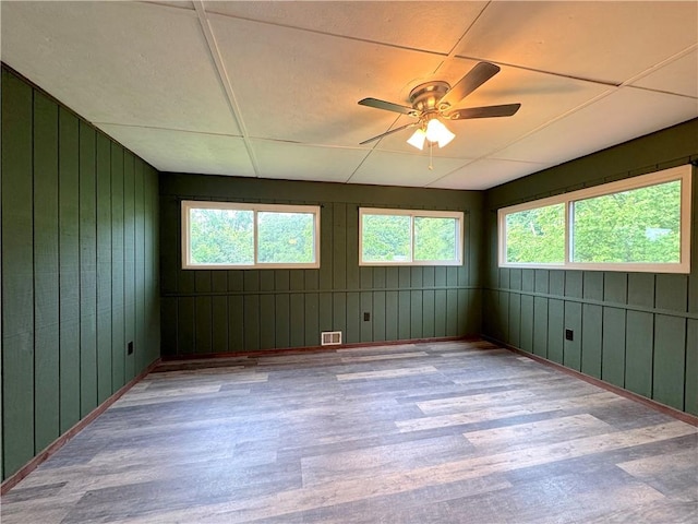 81 Baltimore St, Irwin, PA 15642 - empty room featuring wood finished floors, healthy amount of natural light, wooden walls, and ceiling fan