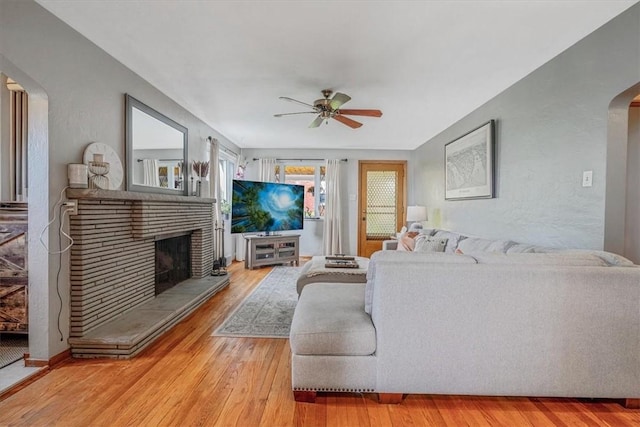 310 Glaser Ave, Bellevue, PA 15202 - living room with arched walkways, a ceiling fan, light wood-style floors, and a brick fireplace