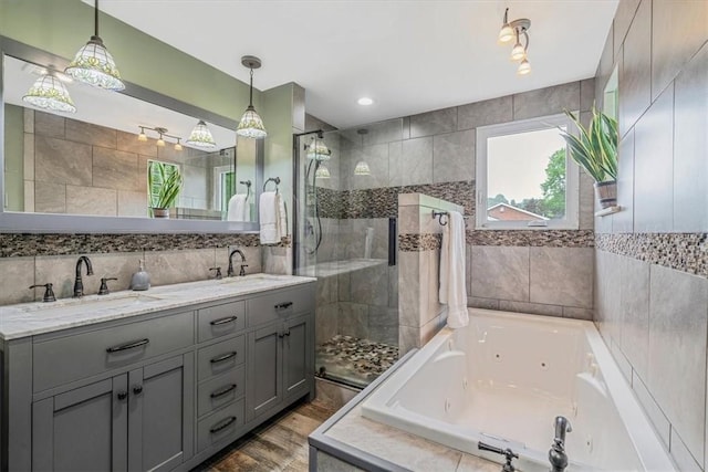310 Glaser Ave, Bellevue, PA 15202 - full bathroom featuring a shower stall, a tub with jets, double vanity, wood finished floors, and tile walls