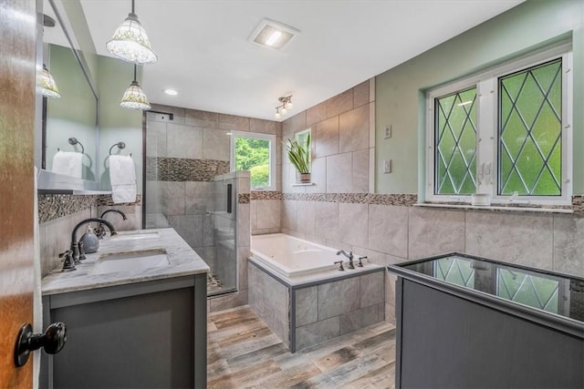 310 Glaser Ave, Bellevue, PA 15202 - full bathroom featuring a bath, double vanity, tile walls, a stall shower, and wood finished floors