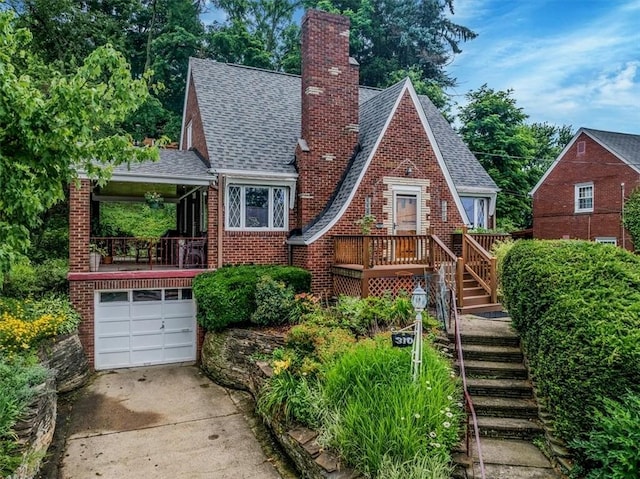310 Glaser Ave, Bellevue, PA 15202 - tudor home featuring a chimney, brick siding, concrete driveway, stairway, and roof with shingles