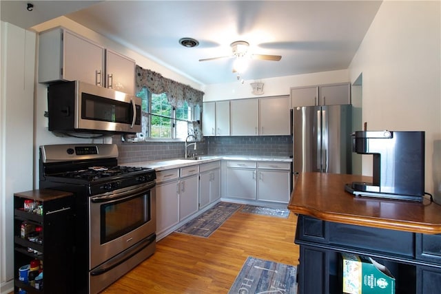 5401 Perrysville Rd, Ross Twp, PA 15229 - kitchen featuring appliances with stainless steel finishes, ceiling fan, light wood-style floors, tasteful backsplash, and light countertops