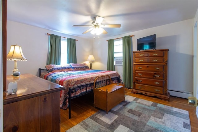 5401 Perrysville Rd, Ross Twp, PA 15229 - bedroom featuring baseboard heating, multiple windows, wood finished floors, and ceiling fan