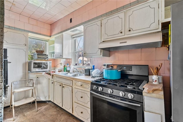 1503 Beechview Ave, Beechview, PA 15216 - kitchen with appliances with stainless steel finishes, under cabinet range hood, light countertops, and tasteful backsplash