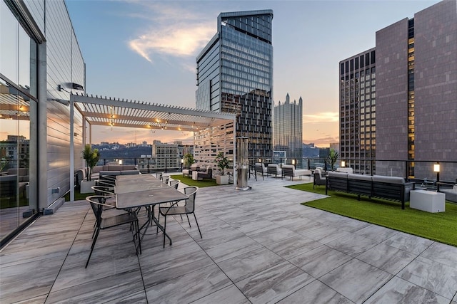 350 Oliver Ave Unit 1301/1401, Downtown Pgh, PA 15222 - patio terrace at dusk featuring an outdoor hangout area, a pergola, and a city view