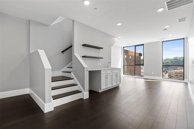 350 Oliver Ave Unit 1301/1401, Downtown Pgh, PA 15222 - unfurnished living room featuring dark wood finished floors, recessed lighting, stairs, and a wall of windows