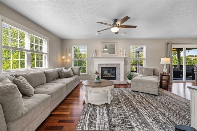 706 Williamsburg Ct, Cranberry Twp, PA 16066 - living area featuring plenty of natural light, a textured ceiling, a ceiling fan, dark wood-style floors, and a brick fireplace