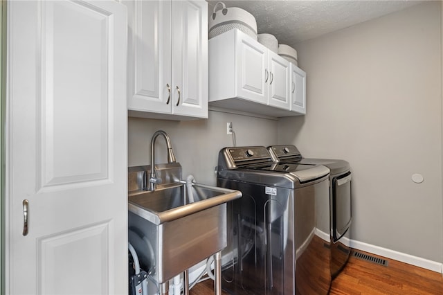 706 Williamsburg Ct, Cranberry Twp, PA 16066 - laundry area with washer and clothes dryer, cabinet space, wood finished floors, and a textured ceiling