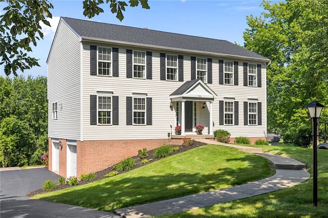 706 Williamsburg Ct, Cranberry Twp, PA 16066 - colonial house featuring an attached garage, a front yard, driveway, and brick siding
