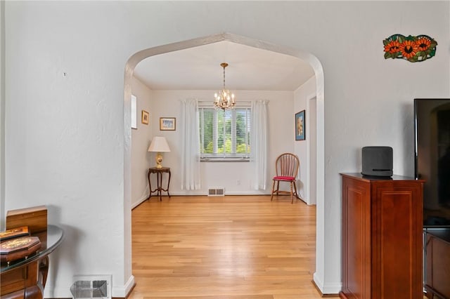 418 Sylvania Dr, Ross Twp, PA 15229 - dining room with arched walkways, light wood finished floors, and a chandelier