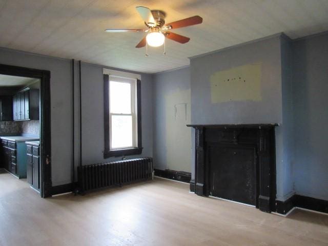 103 Memorial St, Dunbar, PA 15431 - unfurnished living room with radiator, a ceiling fan, a fireplace, and light wood-type flooring