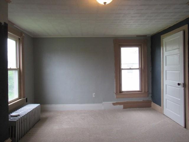 103 Memorial St, Dunbar, PA 15431 - carpeted empty room with radiator and plenty of natural light