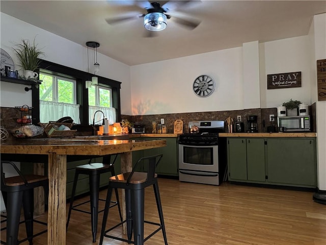 1418 Neshannock Blvd, New Castle/2Nd, PA 16105 - kitchen featuring stainless steel range with gas stovetop, green cabinets, ceiling fan, and backsplash