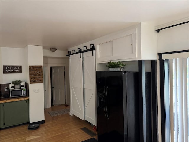 1418 Neshannock Blvd, New Castle/2Nd, PA 16105 - kitchen featuring black fridge, stainless steel microwave, light wood-type flooring, and a barn door